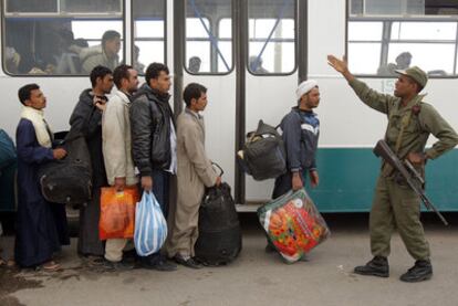 Varios refugiados libios llegan ayer a la frontera tunecina de Ras el Ajdir.