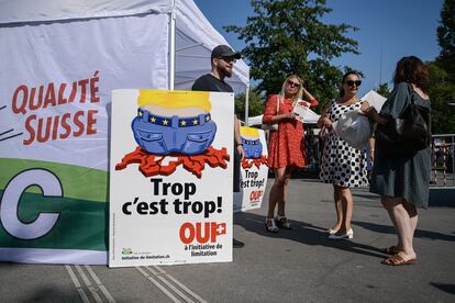 Militantes de la derecha nacionalista suiza junto a un cartel de la campaña para frenar la inmigración, el 13 de septiembre en Ginebra.