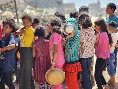 Niños palestinos esperan en la cola de reparto de ayuda humanitaria de World Central Kitchen este lunes en Bani Suheyle, al este de Jan Yunis.