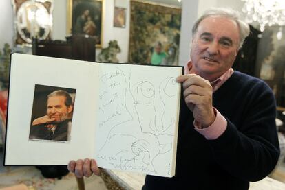Germán Elzo, responsable de Subastas Bilbao XXI, sostiene uno de los libros de visitas de Casa Nicolasa por los que se pujó ayer, abierto por la página en la que firmó el actor Jeff Bridges.