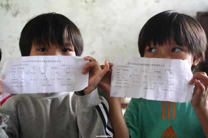 Imagen fechada en agosto de 2009 en la que dos niños chinos muestran el resultado de sus análisis, con niveles altos de plomo, en la provincia de Hunan.