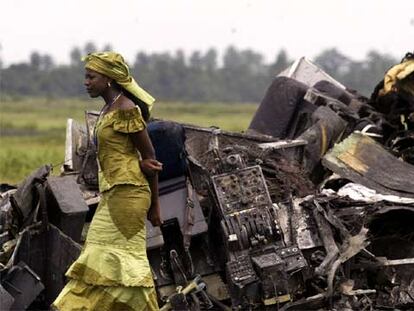 Una mujer camina entre los restos del avión que se estrelló el sábado cerca de Port Harcourt.