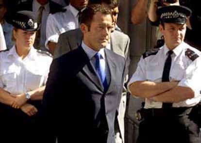 El que fuera mayordomo de Lady Di, Paul Burrell, abandona el tribunal rodeado por la policía.