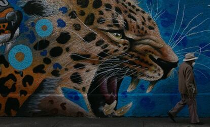 Un hombre camina frente a uno de los murales de la calle Comonfort.