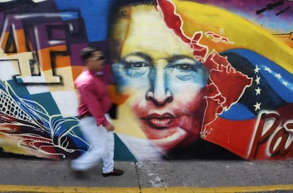 Un hombre camina frente a un mural dedicado a Ch&aacute;vez en Caracas.