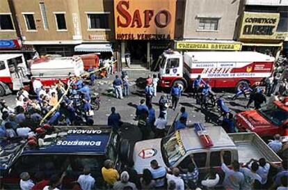 La policía y los bomberos inspeccionan el club La Guajira, que ardió el sábado por la noche en el centro de Caracas.