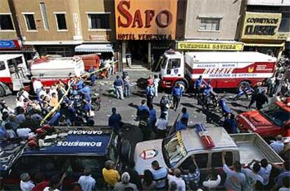 La policía y los bomberos  inspeccionan el club La Guajira, que ardió el sábado por la noche en el centro de Caracas.