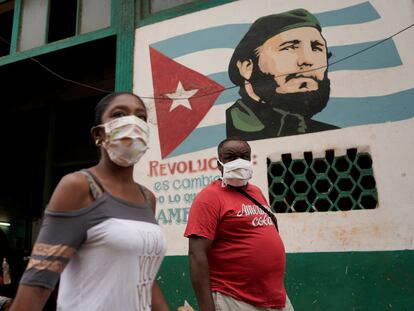 Dos peatones caminan frente a una imagen de Fidel Castro, este domingo en La Habana.