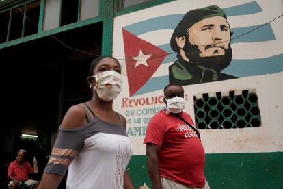 Pedestres caminham diante de uma imagem de Fidel Castro, neste domingo, em Havana.