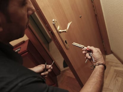 Un cerrajero cambia el bombín de una puerta tras el robo en una casa.