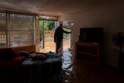 Un hombre en su casa inundada por las lluvias en Les Cases d'Alcanar, este domingo en Tarragona.