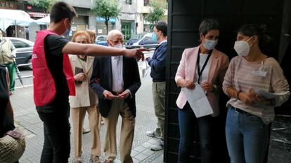 Unos votantes se dirigen a las urnas en un colegio electoral de Bilbao (Bizkaia) este domingo.