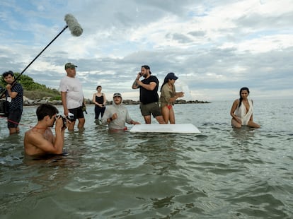 Padma Lakshmi rodeada del equipo durante la sesión de fotos en una playa en Miami.