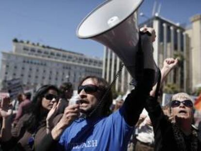 Un funcionario utiliza un megáfono durante una protesta por los despidos y fusiones de organismos públicos, en el centro de Atenas (Grecia) hoy.