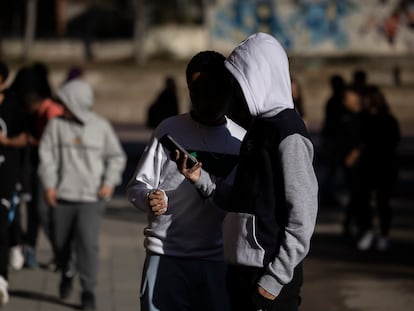 Adolescentes usando el teléfono durante el recreo en un instituto del área de Barcelona.