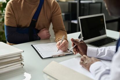 Un trabajador rellena información sanitaria en la consulta médica.