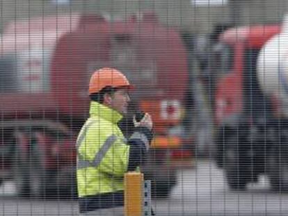 Un operario habla por un "walkie-talkie" mientras unos camiones cisterna esperan para cargar gasolina en el depósito de combustible de Kingsbury, Reino Unido. EFE/Archivo