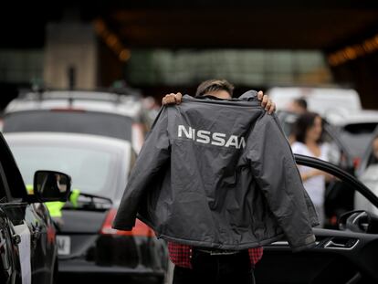 Un trabajador muestra una chaqueta de Nissan durante la protesta.