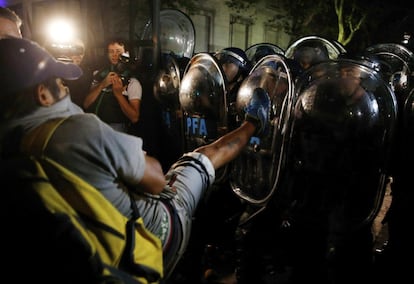 Los argentinos han vuelto este lunes a las calles para exigir que se aclare la muerte del fiscal Alberto Nisman, último capítulo de una tragedia que comenzó hace 20 años con uno de los atentados más sangrientos de la historia del país. En la imagen, un manifestante se enfrenta a la policía durante la protesta por la muerte de Nisman en Buenos Aires (Argentina).