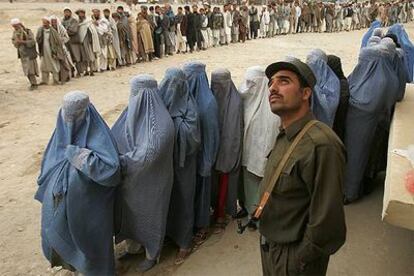 Mujeres afganas, vestidas con <i>burka,</i> hacen cola para votar en un colegio electoral de Kabul.