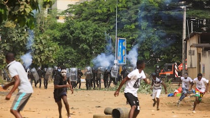 Manifestantes protestando contra el presidente Alassane Outtara huyen del gas lacrimógeno en Abidjan, el pasado 13 de agosto.