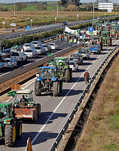 Agricultores convocados por Asaja cortan la autovía que une Sevilla y Huelva en protesta por la crisis en el campo.