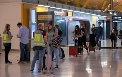 Control de seguridad en el aeropuerto de Barajas en octubre, con tiendas cerradas al fondo.