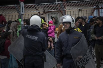 Una niña observa a los antidisturbios griegos a la entrada del puerto de Mitilene.