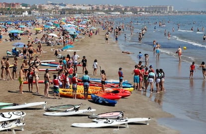 Miles de turistas en la playa de la Malvarrosa de València .