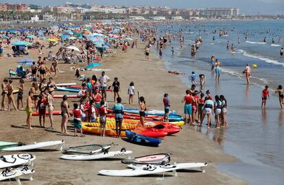 Miles de turistas en la playa de la Malvarrosa de València .