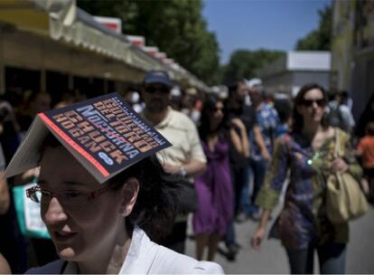 Una mujer se resguarda del sol con un libro.