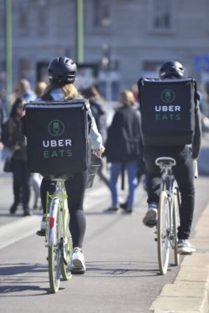Repartidores de UberEATS sirviendo pedidos en bicicleta.