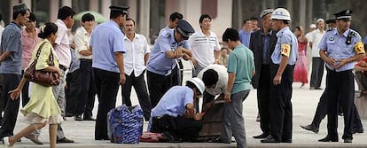 Policías chinos registran las maletas de ciudadanos uigures en Kashgar, en la región de Xinjiang.