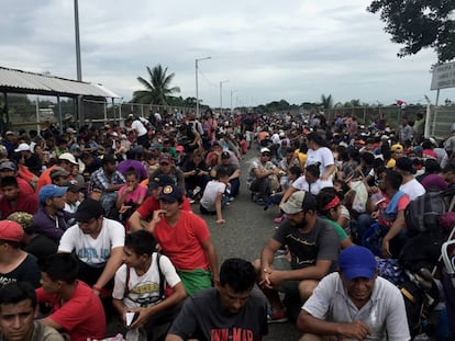 Imigrantes centro-americanos aguardam para entrar no México junto à ponte do rio Suchiate.