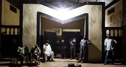 Moffou es un centro cultural que el cantante y compositor maliense Salif Keita posee en Bamako (Malí) y que dispone de dos salas de conciertos, una radio y un estudio de grabación. En esta fotografía, tomada el 28 de junio de 2014, se ve al artista, de blanco, hablando por teléfono a sus puertas en un descanso de los ensayos de Les Ambassadeurs. A su izquierda, se sienta Madibo Kone, percusionista del grupo.