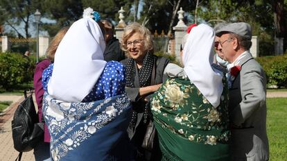 La alcaldesa Manuela Carmena conversa con unos chulapos en el Parque del Oeste.