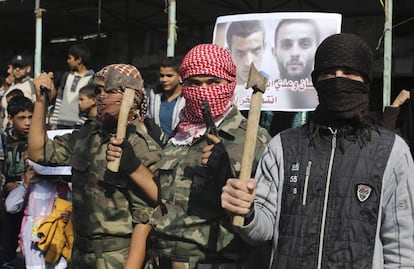 Palestinos enmascarados y armados celebran el ataque a la sinagoga en el que dos asaltantes han irrumpido con hachas y cuchillos en el templo y han matado a cuatro fieles antes de ser abatidos.