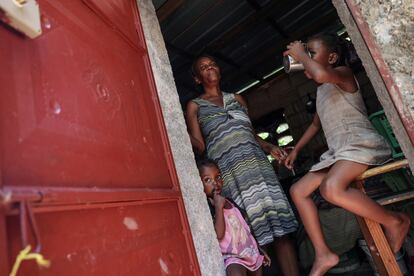 Rita Losandieu, de 53 años, frente a su casa con sus nietas, Solius, de 4 años, y Alisha, de 6, en la zona de Monoville del barrio de Juvenat en Puerto Príncipe, el 7 de mayo. "Para comprar algo de comer se necesita mucho dinero. Es muy difícil", decía Losandieu, cuyos dos hijos tienen trabajos ocasionales para llegar a fin de mes. 