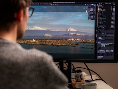 Kole, en su ordenador ante una imagen en la que aparecen de fondo los dos mayores volcanes del valle.