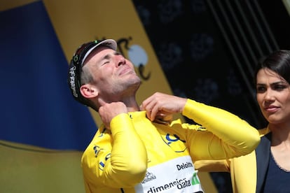 Mark Cavendish enfundandose el maillot amarillo.