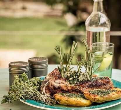</p> <p><em>Ingredientes.</em> Para 4 personas: 1 chuletón de buey o vaca de unos 800 gramos, 4 patatas nuevas medianas, mantequilla aromatizada con hierbas y especias al gusto (con cebollino, albahaca, perejil, romero, pimienta, pimentón, comino, chile, ajo…), sal en escamas, pimienta. </p> <p><em>Preparación/em> 1. Sacar el chuletón de la nevera dos horas antes de hacerlo. Preparar la mantequilla mezclándola con las especias y las hierbas lavadas y finamente picadas. Enrollar en un cilindro de papel de horno o transparente de cocina y refrigerar. Envolver las patatas bien lavadas en papel de plata y ponerlas en las brasas durante 45 minutos, dándoles la vuelta cada 10 y comprobando la cocción a partir de los 30. Poner el chuletón a la brasa, calculando un minuto por cada lado por cada centímetro de grosor. Servir acompañado de las patatas, con escamas de sal Maldon y la cantidad de mantequilla que se quiera. 2. Para que el chuletón quede en su punto es básico que esté a temperatura ambiente; de lo contrario, quedará demasiado hecho por fuera o estará todavía frío en el interior, lo que afectará al sabor. Vale la pena preparar mayor cantidad de mantequilla de hierbas y guardarla para utilizarla con pasta, pollo o pescado, o como aperitivo con pan, tostadas y ahumados. Agradecimiento: Genuinus.