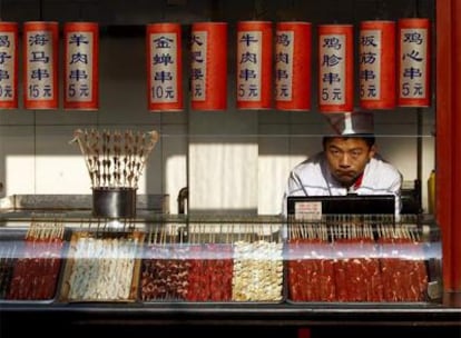 Un dependiente espera la llegada de clientes en un puesto de comida, el pasado viernes, en Pekín. El Gobierno teme una caída del consumo.