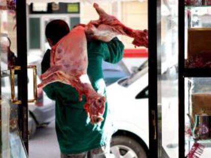 En la imagen, un carnicero transporta unos corderos sacrificados orientados a la Meca, con un corte seco y limpio bajo en cuello y pronunciando una oración en el momento de darle muerte. EFE/Archivo