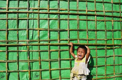 Una niña rohingya reacciona mientras espera a su madre que ha ido a buscar ayuda humanitaria cerca del campamento para refugiados del distrito Ukhia de Bangladesh. 