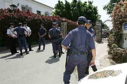 Agentes de policía custodian la casa de Julián Muñoz durante el registro policial.
