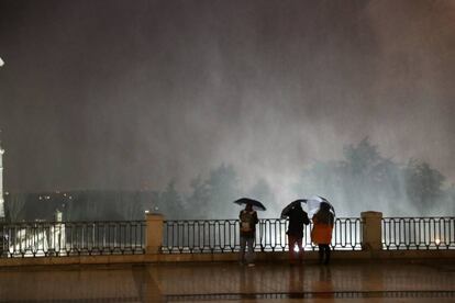 -FOTODELDÍA- GRAF3017. MADRID, 01/03/2018.- Varias personas observando las partículas de agua en suspensión debido al fuerte viento en la Plaza de Oriente, junto al Palacio Real de Madrid. EFE/Zipi