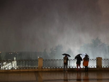 -FOTODELDÍA- GRAF3017. MADRID, 01/03/2018.- Varias personas observando las partículas de agua en suspensión debido al fuerte viento en la Plaza de Oriente, junto al Palacio Real de Madrid. EFE/Zipi