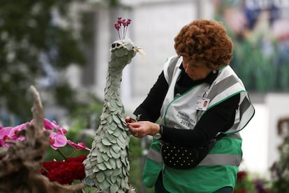 Una trabajadora termina una escultura de flores y pétalos en el Chelsea Flower Show de Londres.