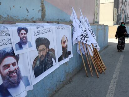 Dos afganas pasan junto un puesto de venta de banderas y carteles con la imagen de líderes talibanes el jueves en Kabul.