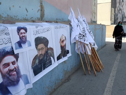 Dos afganas pasan junto un puesto de venta de banderas y carteles con la imagen de líderes talibanes el jueves en Kabul.